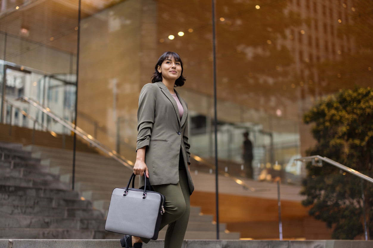 A confident professional outside a modern headquarters